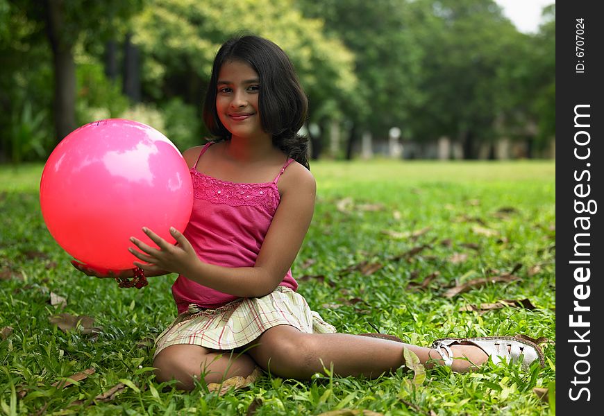 Asian girl of indian origin in the park with her red ball. Asian girl of indian origin in the park with her red ball