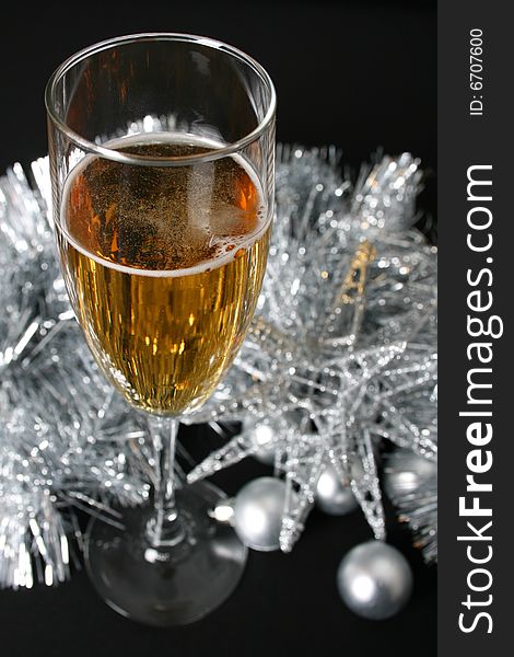 Glass of sparkling wine against silver decorations. Glass of sparkling wine against silver decorations