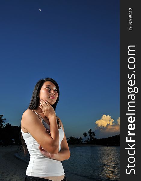 Woman with pondering face at night on the beach. Woman with pondering face at night on the beach.
