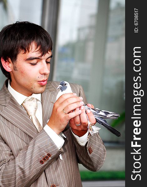 The man costs in a jacket. At it in hands a pigeon
