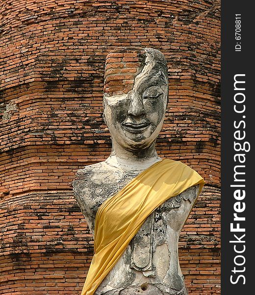 The old and ancient buddha image infront of broken pagoda in Ayuthaya, Thailand
