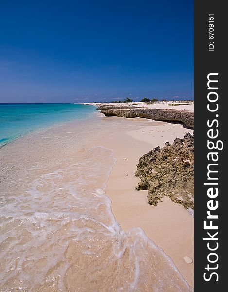 Tropical beach with turquoise sea and rocky shore