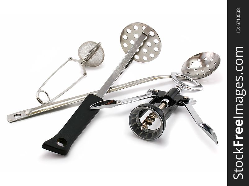 Two perforated spoons, tea strainer and corkscrew isolated on a white background