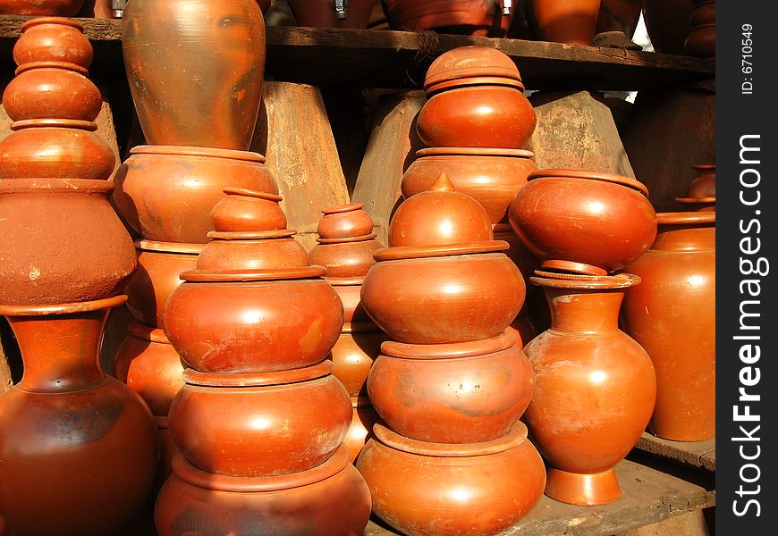 A group of orange colored, different shaped earthen pots, made out of clay