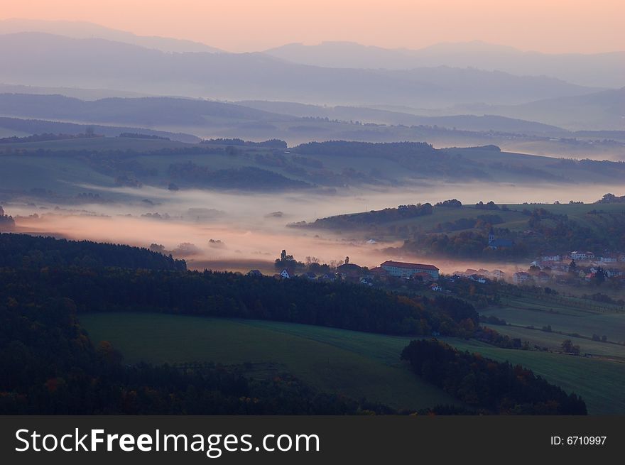 Autumn landscape with fog and coloured tree