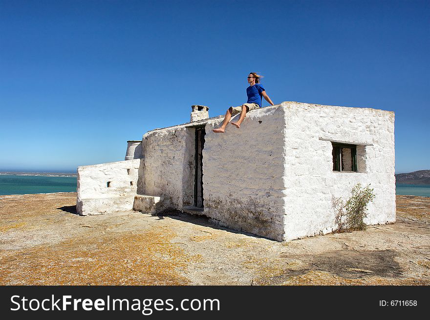 Young man on roof of abandoned house looks at sea