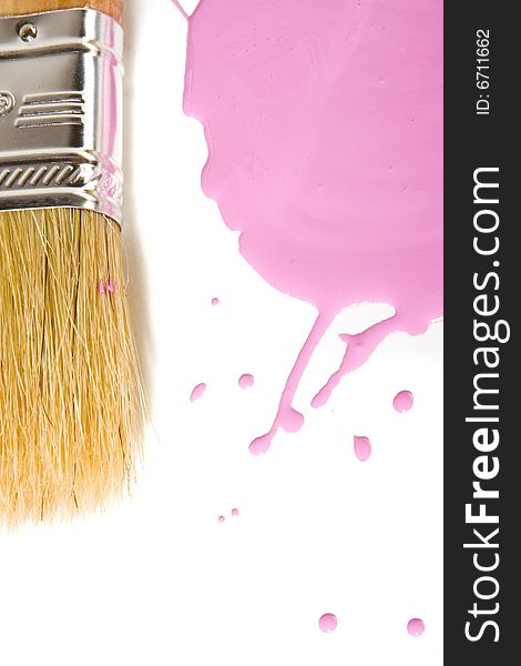 Paintbrush and pink paint on white ground