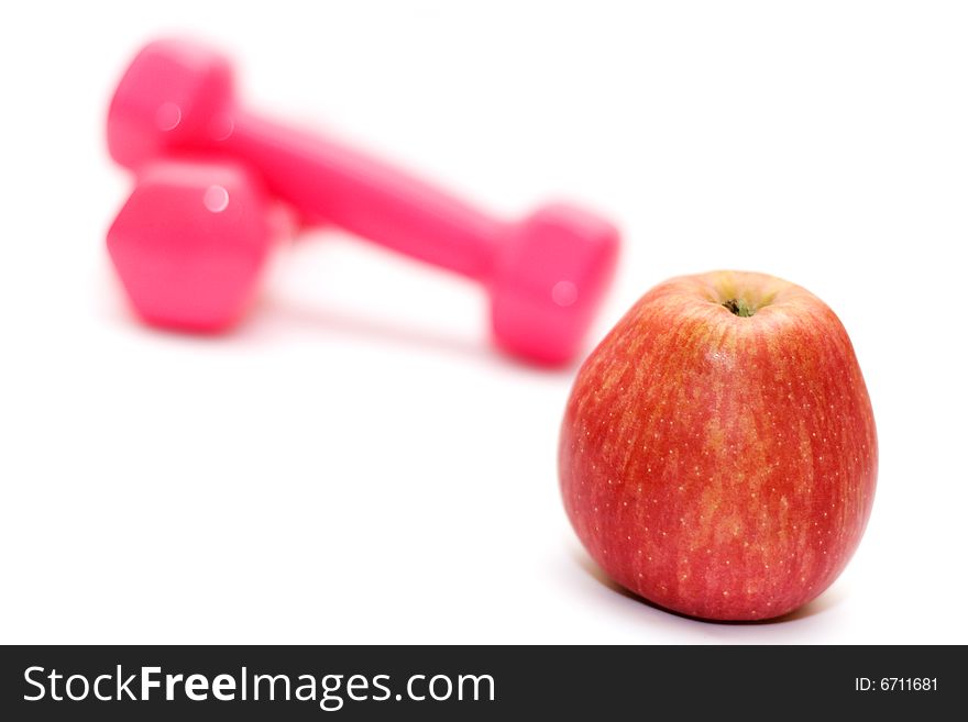 Dumbbells and apple on the white(shallow DOF,focus on apple). Dumbbells and apple on the white(shallow DOF,focus on apple)