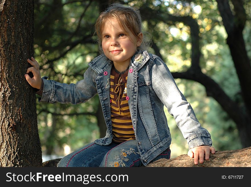 Little girl sitting on the tree. Little girl sitting on the tree