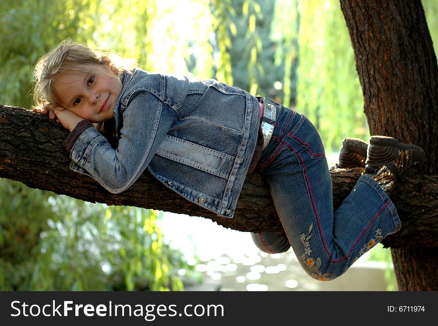 Little girl sitting on the tree. Little girl sitting on the tree