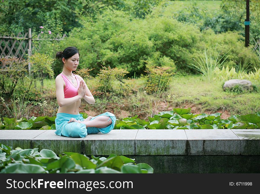 Young chinese woman practicing yoga outdoor