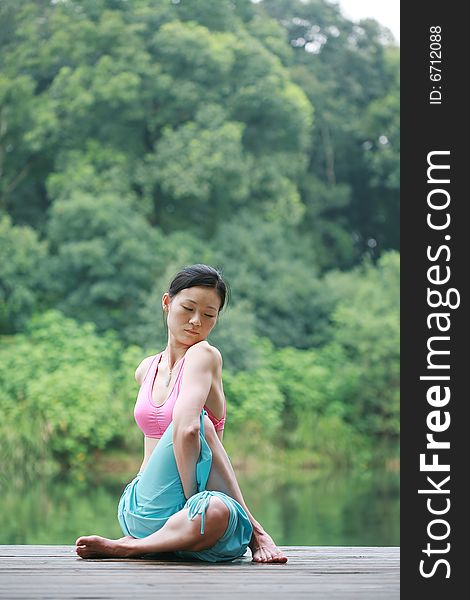 Young chinese woman practicing yoga outdoor