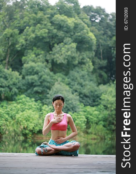 A young chinese woman practicing yoga in the outdoors. A young chinese woman practicing yoga in the outdoors