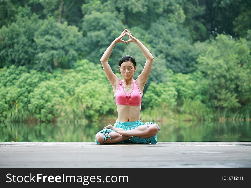 Young chinese woman practicing yoga outdoor