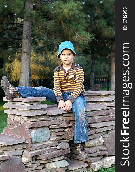 Little girl sitting on the stones. Little girl sitting on the stones