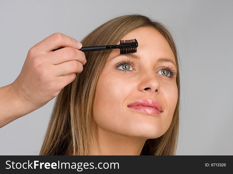 Pretty woman applying make up.