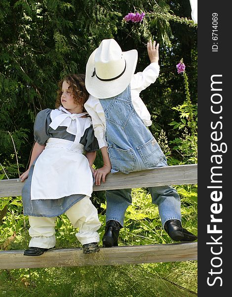 Young boy picking flowers for a young girl. Young boy picking flowers for a young girl