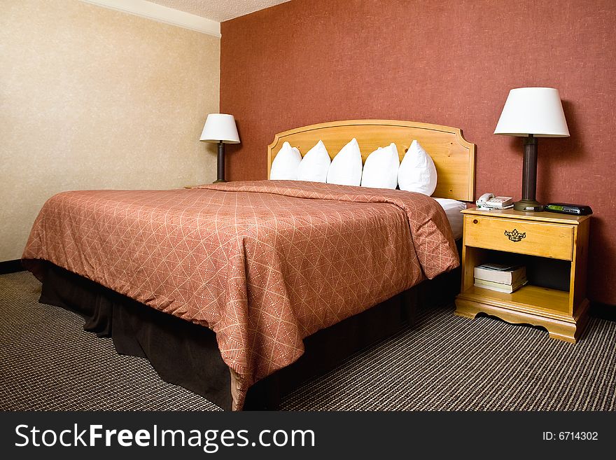 A simple hotel room with a large bed. A simple hotel room with a large bed.