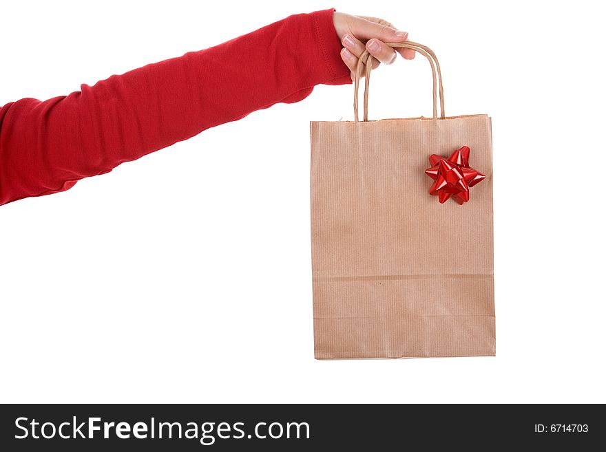 Woman hand holding papper bag with red ribbon isolated on white background