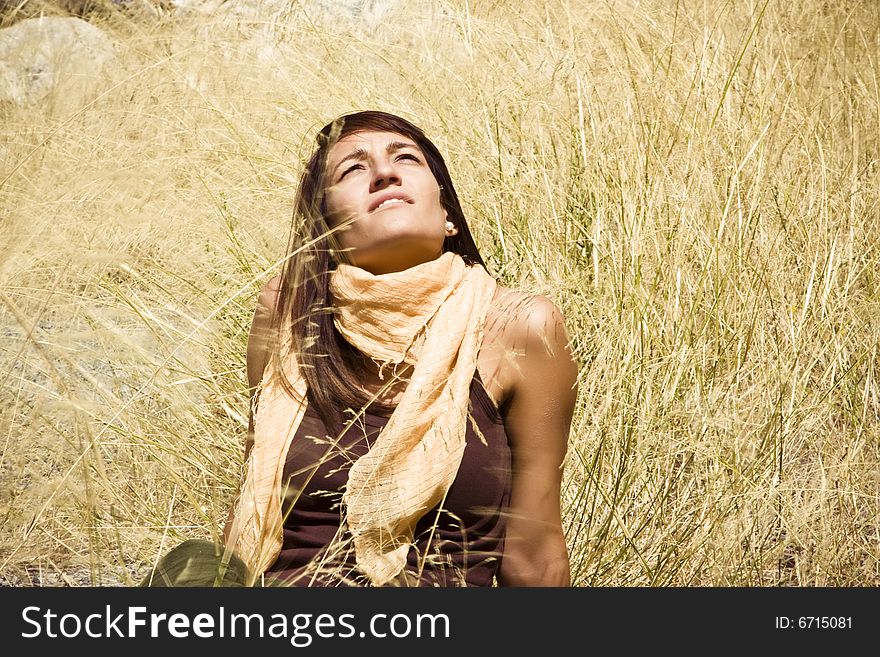 Young woman staring at the sun in the middle of a field. Young woman staring at the sun in the middle of a field.