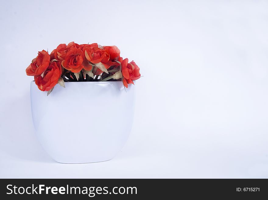 A floral arrangement of orange flowers in white vase. A floral arrangement of orange flowers in white vase