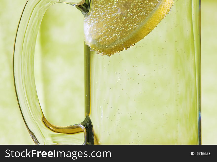 Lemon slice floating in a transparent glass full with sparkling water (club soda). Lemon slice floating in a transparent glass full with sparkling water (club soda)