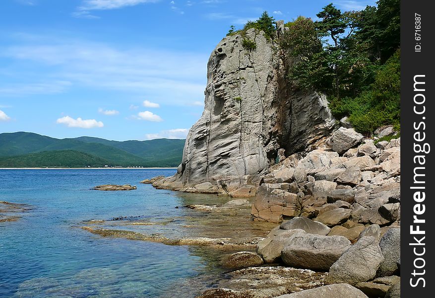 A very small bay among fancy rocks. Seacoast of Petrova island - pearl of nature state reserve Lazovsky. Russian Far East, Primorye. A very small bay among fancy rocks. Seacoast of Petrova island - pearl of nature state reserve Lazovsky. Russian Far East, Primorye.