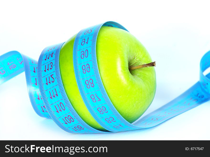 Green apple and measuring tape on white