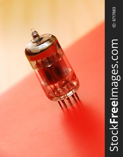 Old vacuum tube on the red background