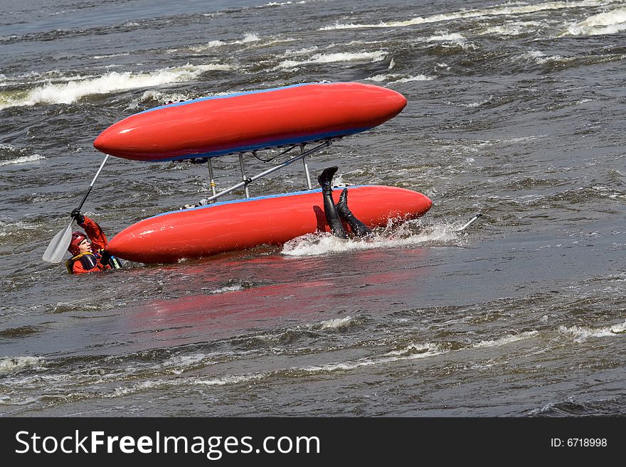 Sportsmen and the upturned catamaran in the rapid