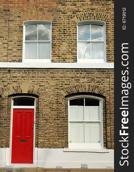 Victorian terraced house with bright red door in East London.
