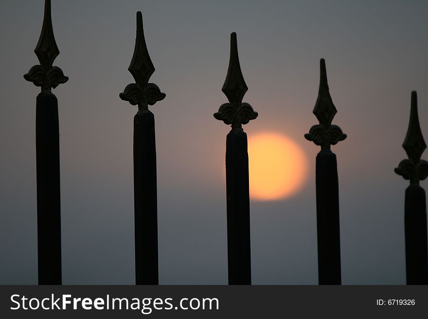 Sunset on background and a fence