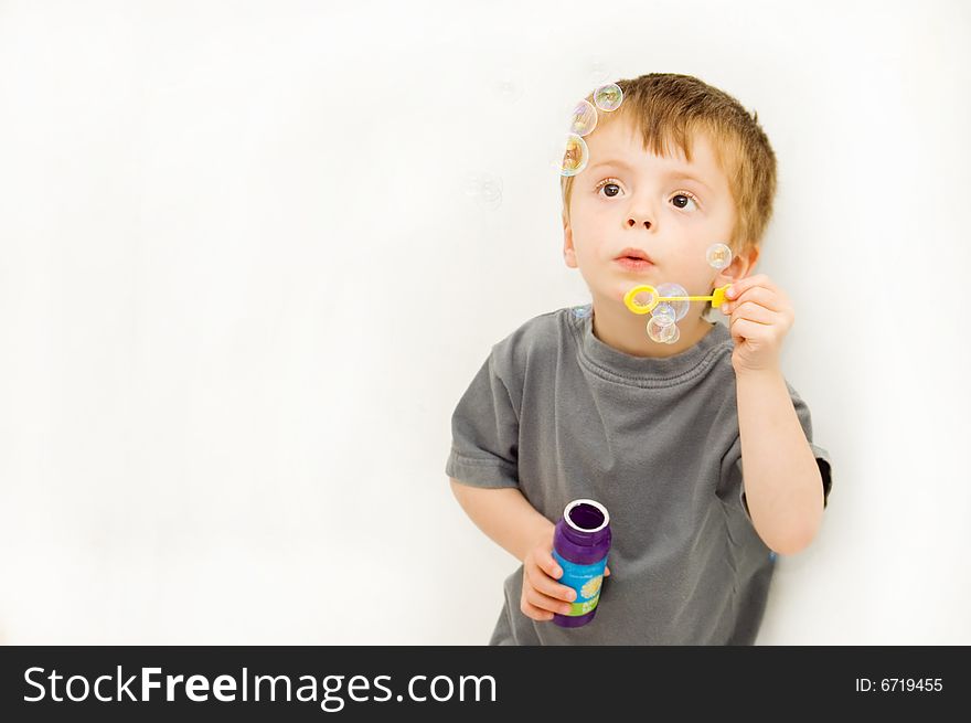 Boy blowing bubbles with great concentration.