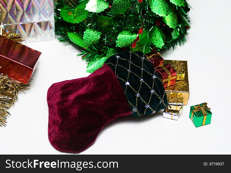 Christmas scene with focus on a pretty stocking bursting with presents. Christmas scene with focus on a pretty stocking bursting with presents.