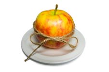 Apple Tied With Twine On A White Plate Closeup Stock Image