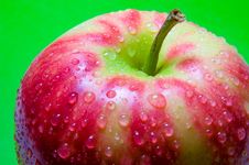 Drops Of Water On An Apple Closeup On A Green Background Stock Image