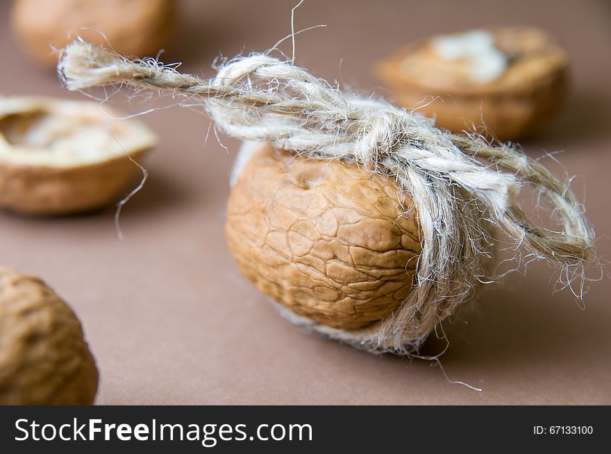 Walnut tied with twine on the blurred background on a brown