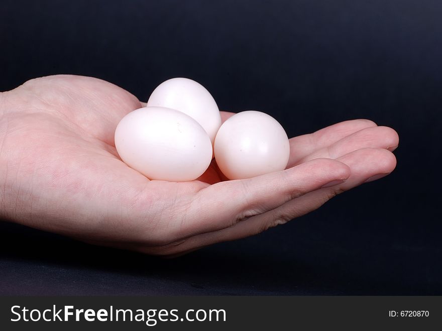 Group of eggs in  hand isolated on black background. Group of eggs in  hand isolated on black background