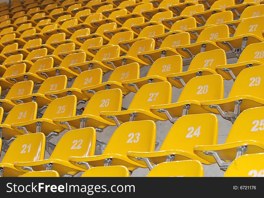 The yellow block of seats in stadium. All seats are numbered.