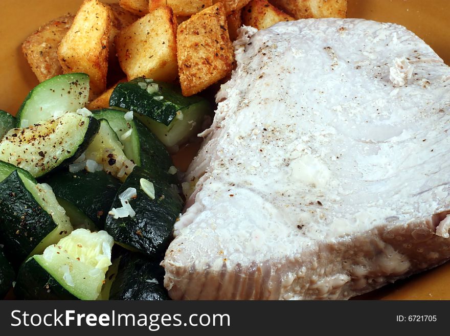 This is a close up image of a tuna filet, potatoes, and vegetables. This is a close up image of a tuna filet, potatoes, and vegetables.