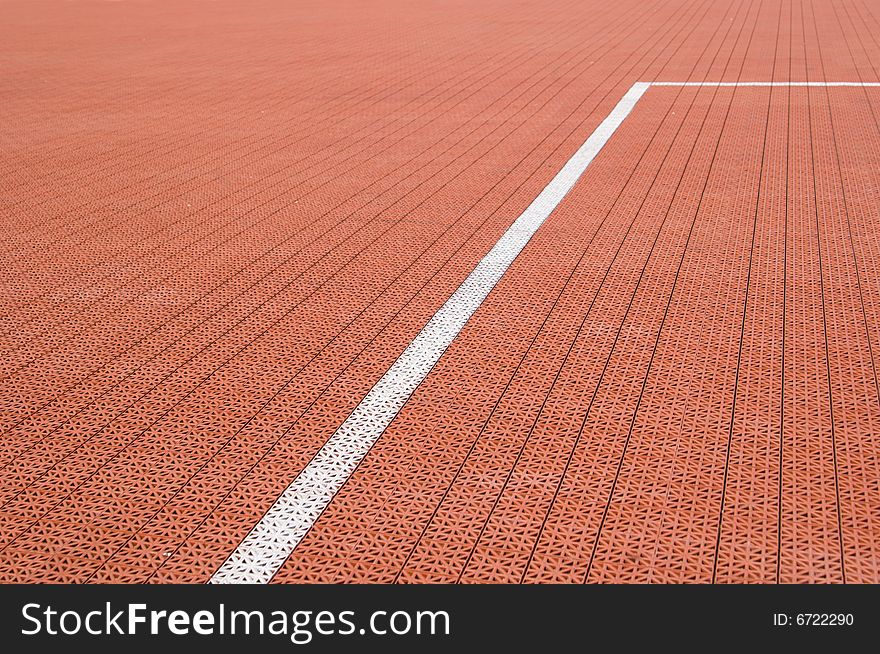Brown artificial tennis court cover with white line