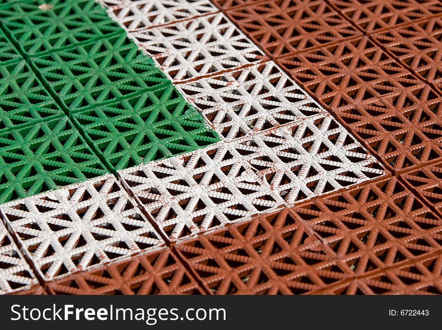 Artificial tennis court cover, brown and green with white line, close-up