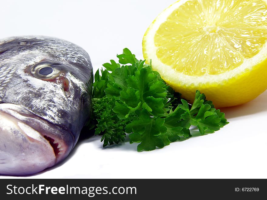 Detail view of a raw sea bream with parsley and lemon. Detail view of a raw sea bream with parsley and lemon.