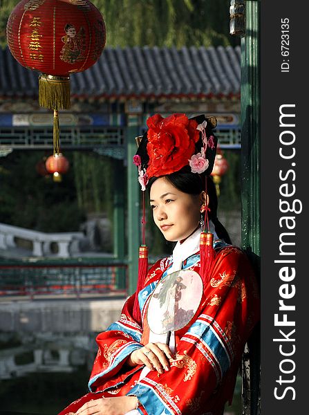 A beautiful girl in Chinese ancient dress is in the royal garden. 
This is dress of Qing Dynasty of China. It is the princess' dress too. 
Chinese on the lantern is a blessing.

Chinese on the fan is meant and missed. A beautiful girl in Chinese ancient dress is in the royal garden. 
This is dress of Qing Dynasty of China. It is the princess' dress too. 
Chinese on the lantern is a blessing.

Chinese on the fan is meant and missed.