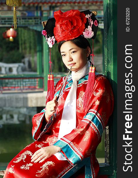 A beautiful girl in Chinese ancient dress is in the royal garden. This is dress of Qing Dynasty of China. It is the princess' dress too. A beautiful girl in Chinese ancient dress is in the royal garden. This is dress of Qing Dynasty of China. It is the princess' dress too.