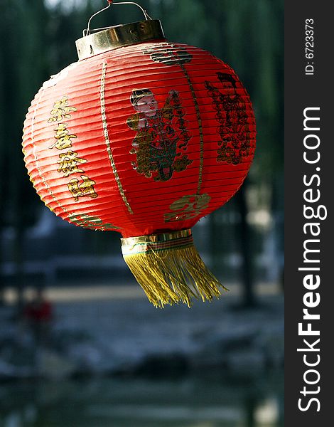 Red lantern on the ancient garden long corridor of China. Chinese on the lantern is lucky and getting rich. Red lantern on the ancient garden long corridor of China. Chinese on the lantern is lucky and getting rich.