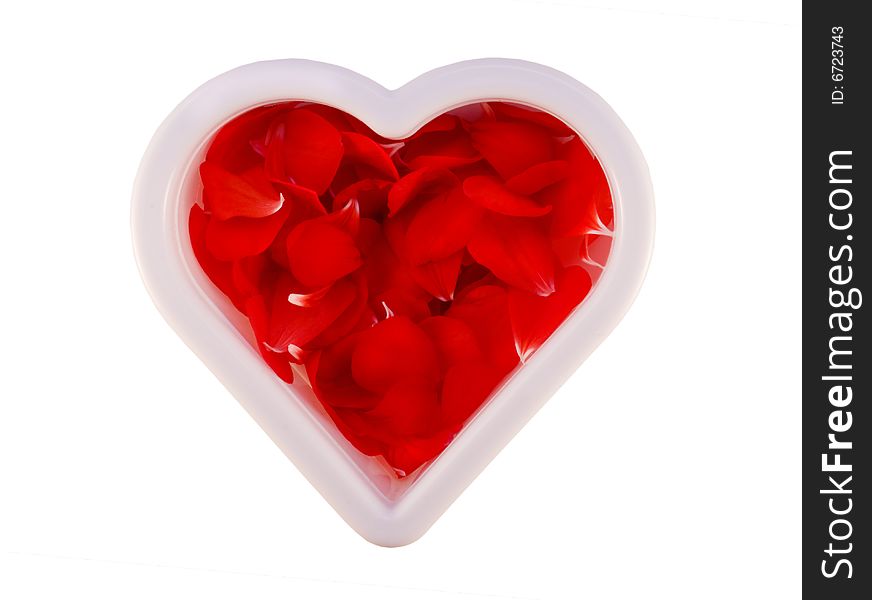 Heart shape cookie cutter filled with red flower petals on white background with clipping path. Heart shape cookie cutter filled with red flower petals on white background with clipping path