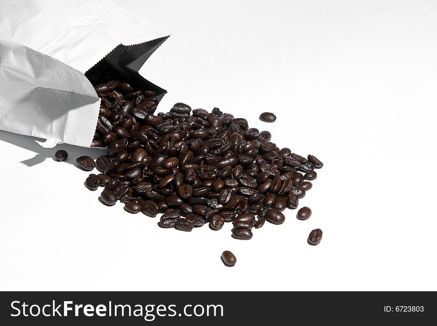 A bag of coffee beans spilled isolated on white