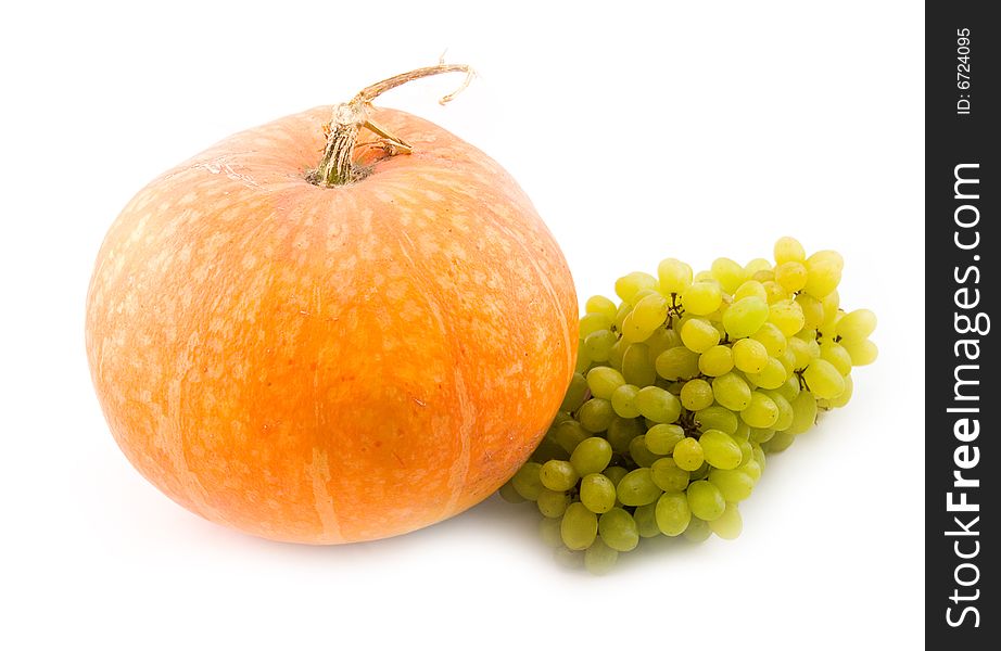 Orange pumpkin and green sweet tasty grapes on white background