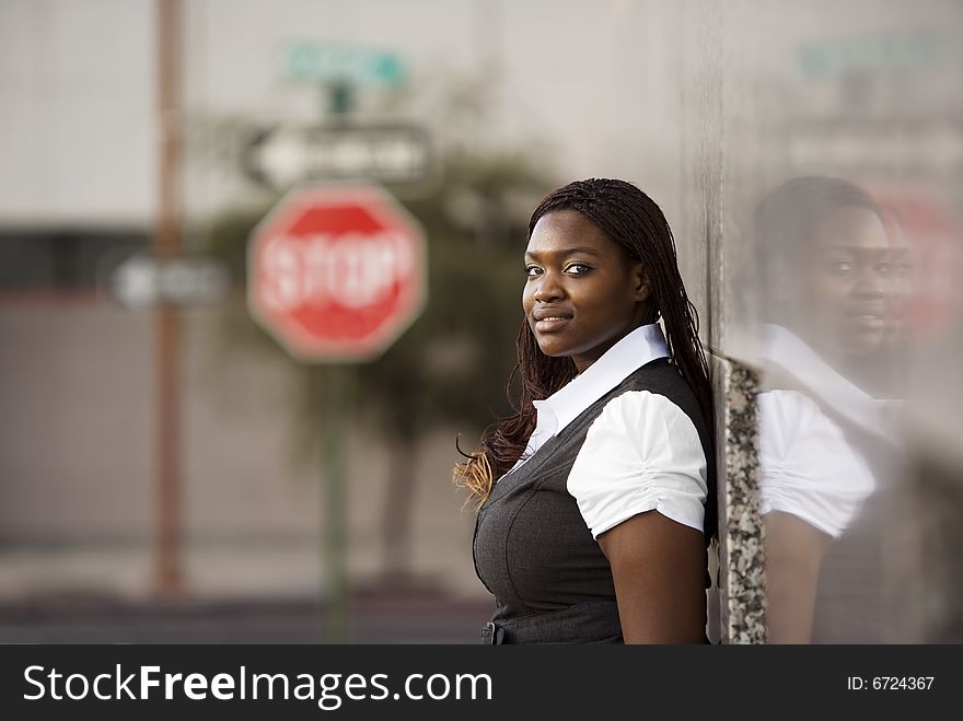 Closeup of a pretty African American woman leaning on a building. Closeup of a pretty African American woman leaning on a building